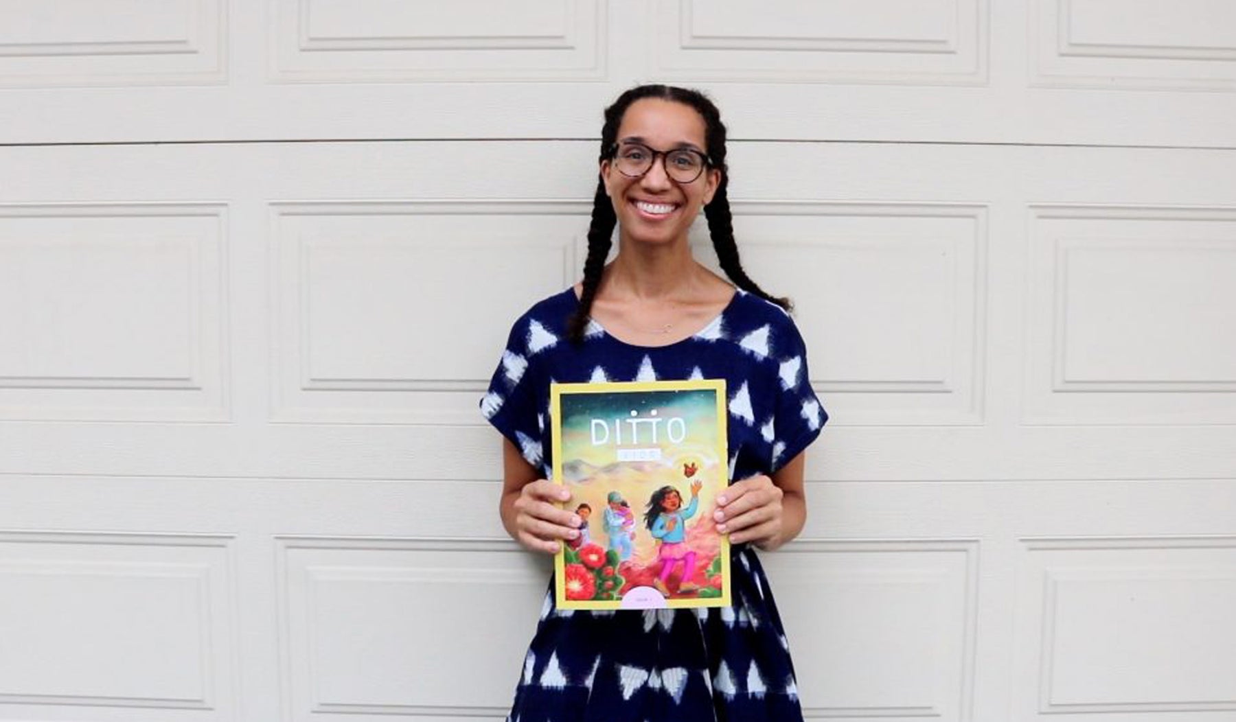 woman with 2 braids and glasses holding ditto kids magazine